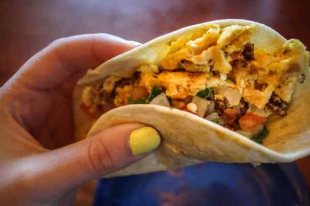 a hand holding a sandwich