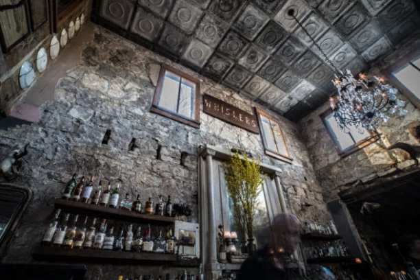 a group of people in a room next to a fireplace