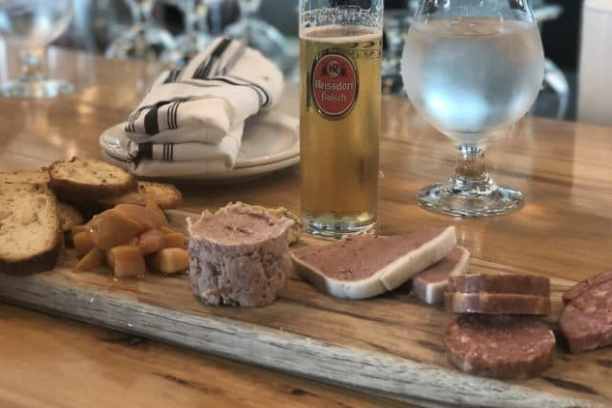 a glass of wine sitting on top of a wooden table