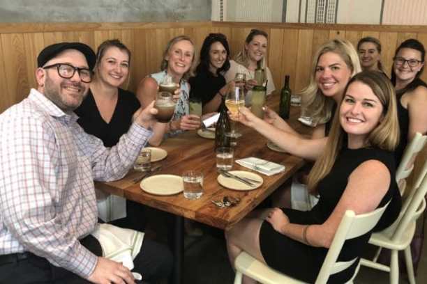 a group of people sitting at a table with wine glasses